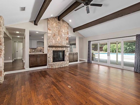 Living room looks out to the private backyard and pool
