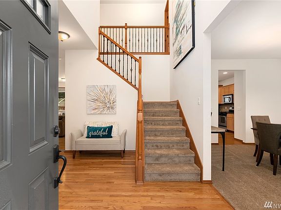 Open foyer style entry with wrought-iron staircase railing.