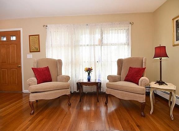 Enter into spacious living room with gleaming hardwood flooring and picture windows.