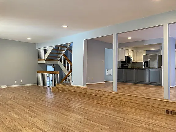 Expansive open-concept living space with hardwood floors, soaring ceilings, and abundant natural light.