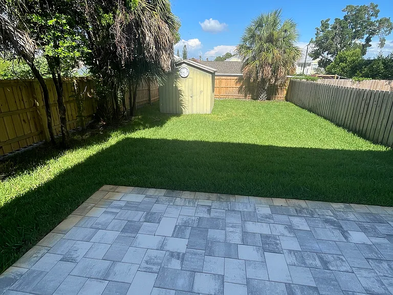 Beautiful and spacious backyard is fully fenced and has a nice paved patio and a shed