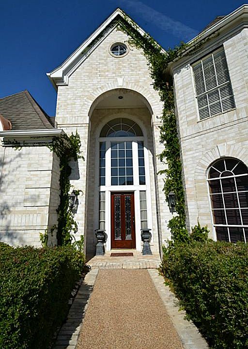 High arched front doorway inviting you inside.