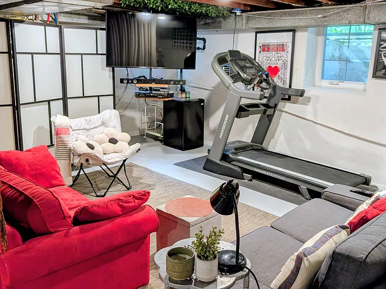 740 sq. ft. basement includes a family room with Smart TV, mini-fridge, treadmill and utility sink