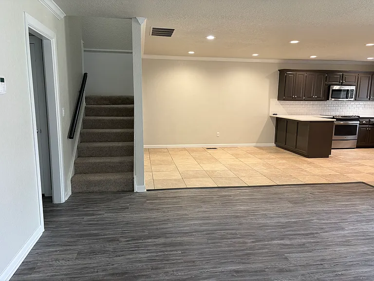 View of stairs to second floor and dining area/kitchen to the left.