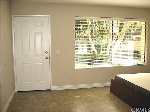 Large living room window overlooks greenery and pool area.