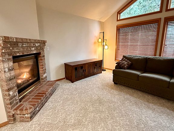 Living room with switch-on gas fireplace and fan.