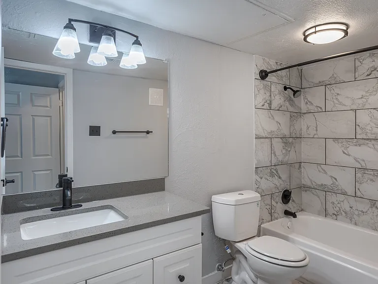 Updated bathroom with modern fixtures and tile tub surround