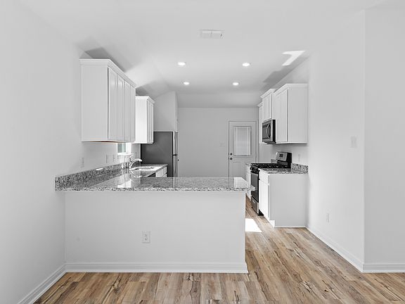 The kitchen boasts beautiful granite countertops and designer wood cabinetry.