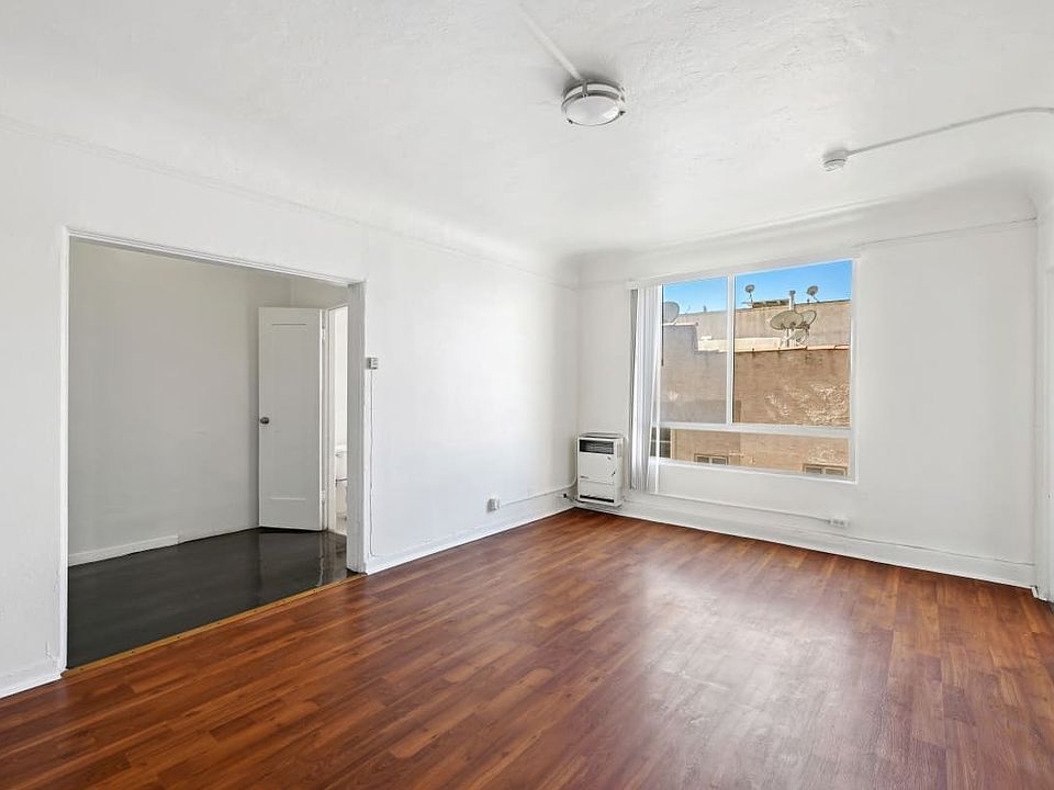 Union an empty living room with hardwood floors and a large window