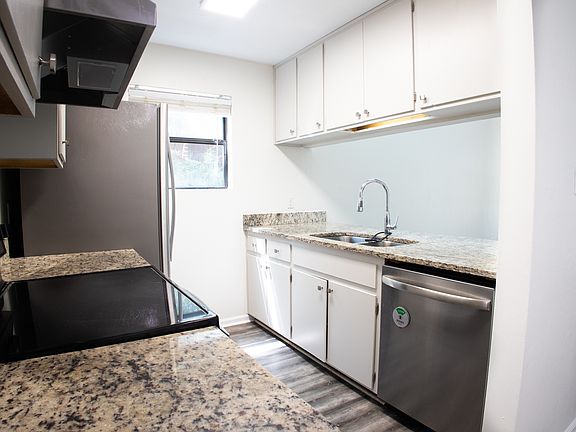 Galley kitchen with granite counters and stainless steel appliances