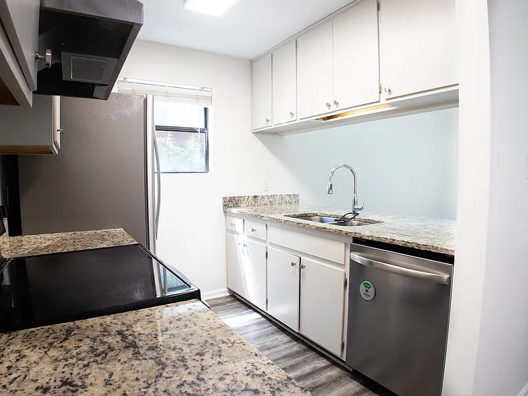 Galley kitchen with granite counters and stainless steel appliances