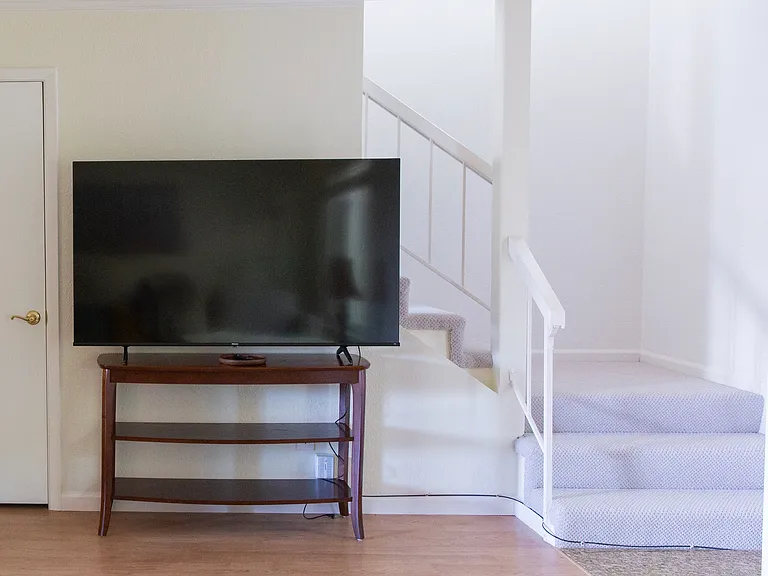 65" smart TV with streaming apps in living room.