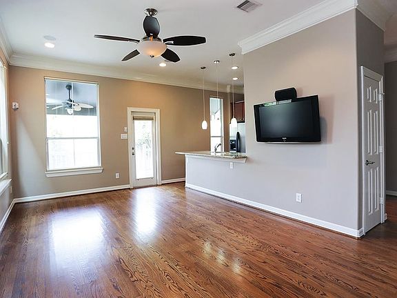 Spacious living room with hardwoods floors and 10" ceilings and large windows that make this home br