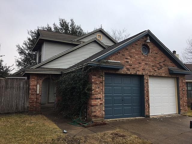 Front of house: two-car garage and courtyard.