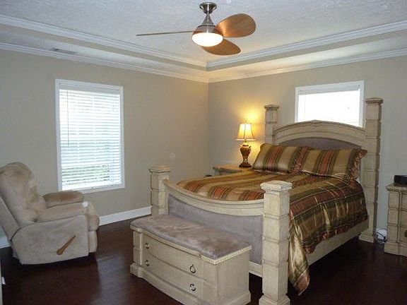 Oversized Master Bedroom with several sunny windows, and enough space for multiple furniture pieces.