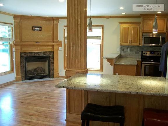 Natural Oak and marble gas fireplace adorn the open kitchen space