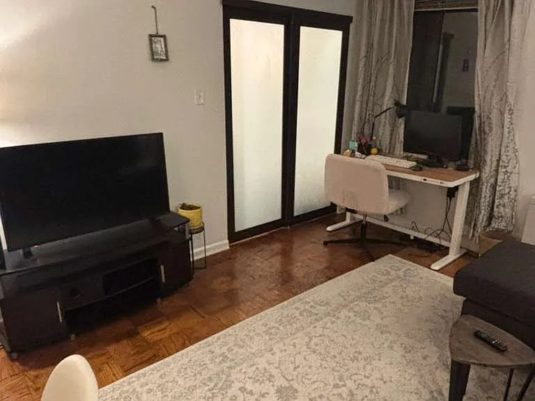 living room focus on TV set and sliding door to the bedroom