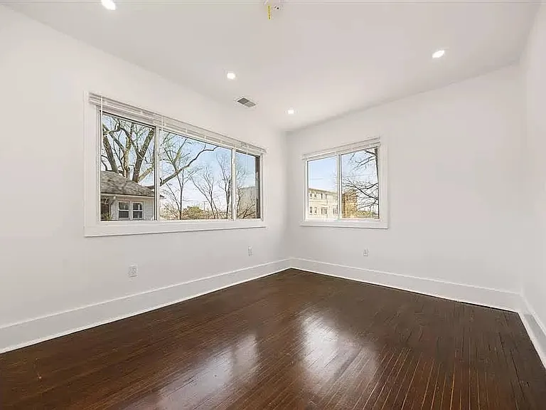 Bedroom
A serene, light-filled bedroom featuring gorgeous dark hardwood floors and expansive windows that offer peaceful views of the neighborhood greenery
