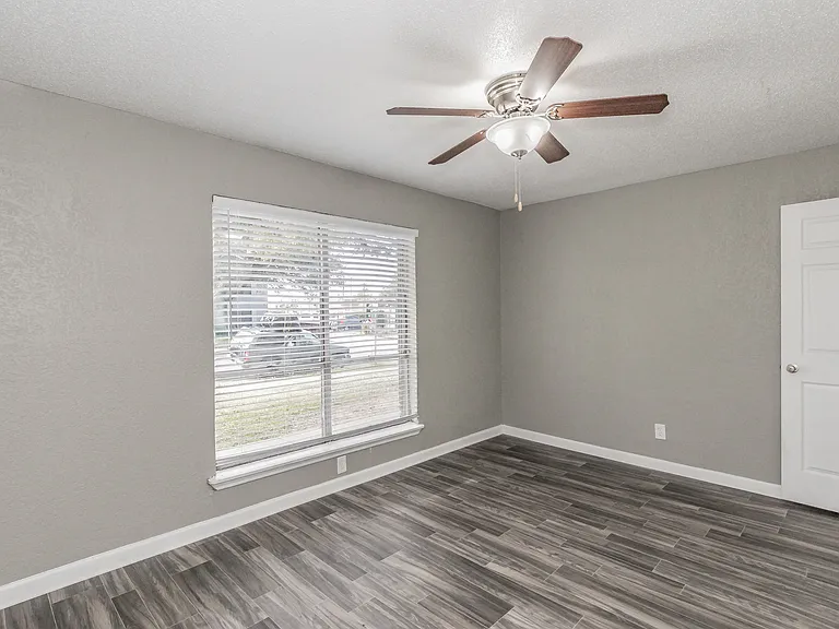 Bedrooms feature neutral finishes, ceiling fans, and ample natural light at Chapel Creek Apartments.