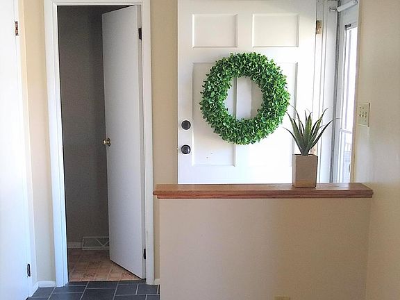 Entrance hall with coat closet. Open door leads to powder room.