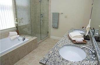 Large master bath with walk in shower, double sinks, and jet
