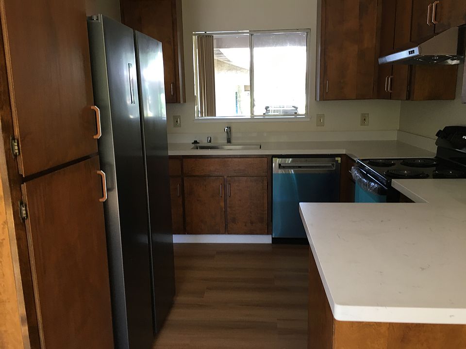 Renovated kitchen with new appliances, new countertops, and new flooring.