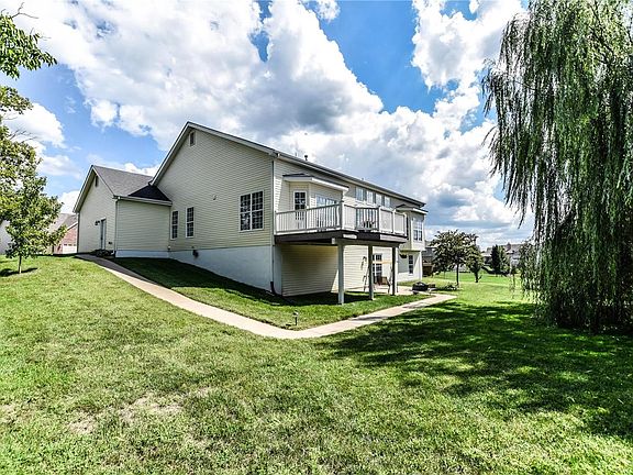Walk-out lower level with sidewalk leading from garage service door around to the patio area.