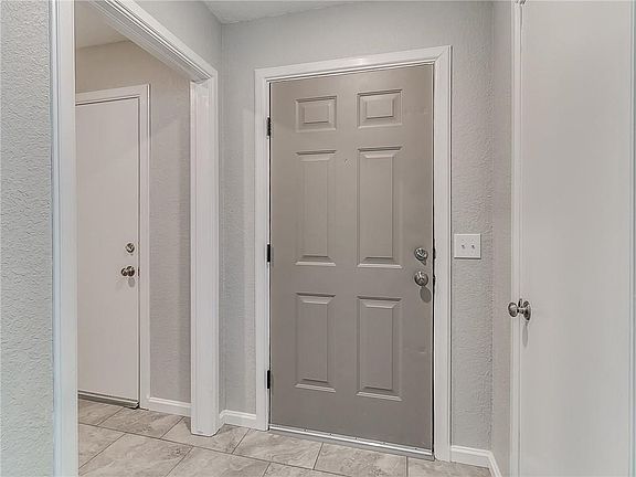 Entry way and coat closet, door to garage. Fresh paint, new flooring
