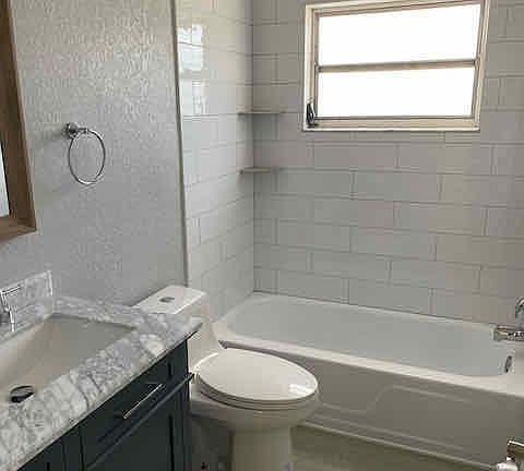 Updated bathroom with fresh tile surround, new vanity with granite top.