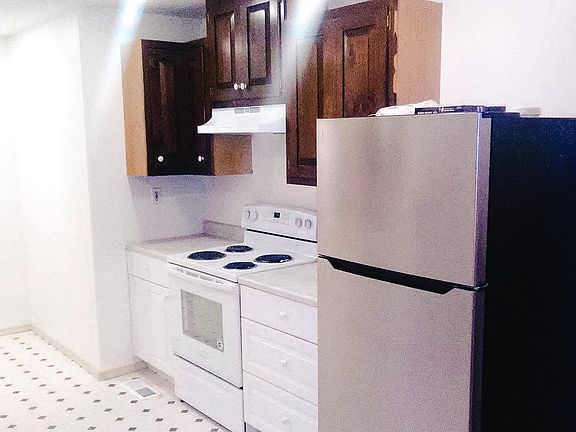Kitchen with partial brand new cabinet. Stove is less than a year old and fridge is brand new.