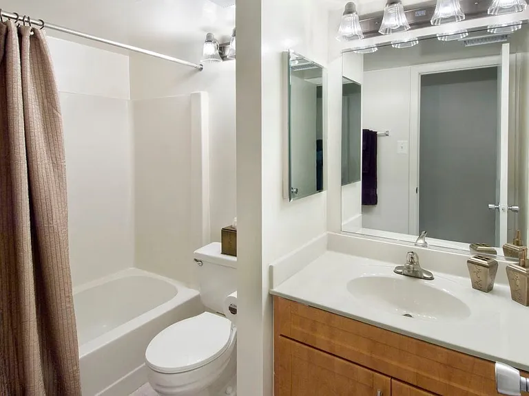 Classic Package bath featuring oak cabinetry and white laminate countertops