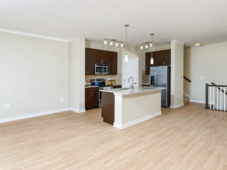 Classic Package II townhome kitchen and living room with hard surface flooring (select homes)