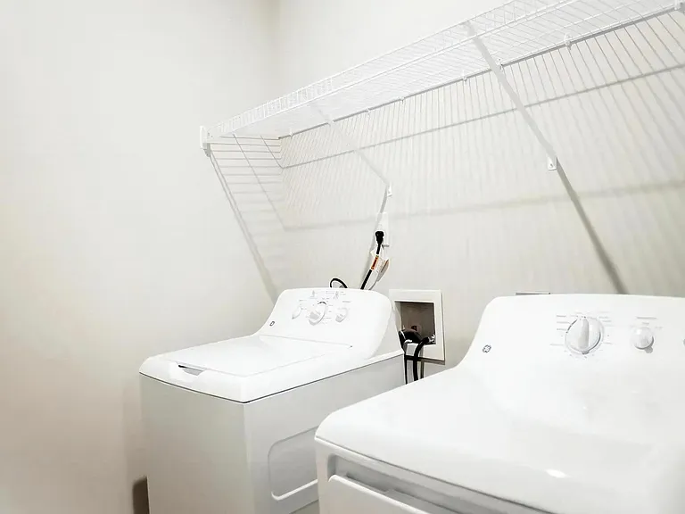 In-Unit Laundry with Full-Size Washer and Dryer and Overhead Wire Shelving