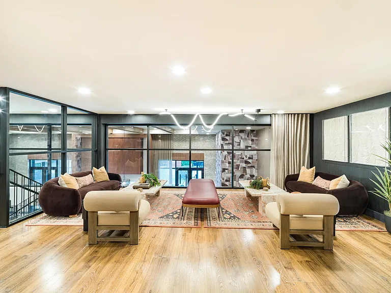 An inviting resident lounge at Modera Higley Commons, designed with layered seating, warm finishes, and a relaxed setting for everyday connection.