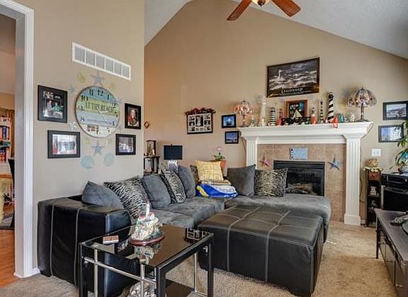 The living room has vaulted ceiling and fan.