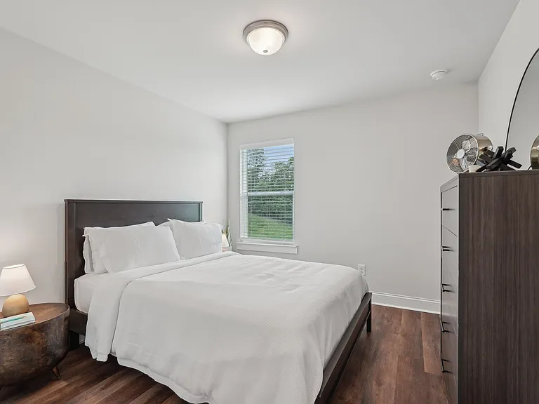 Third bedroom with a queen-size bed and abundant natural light streaming through the window.