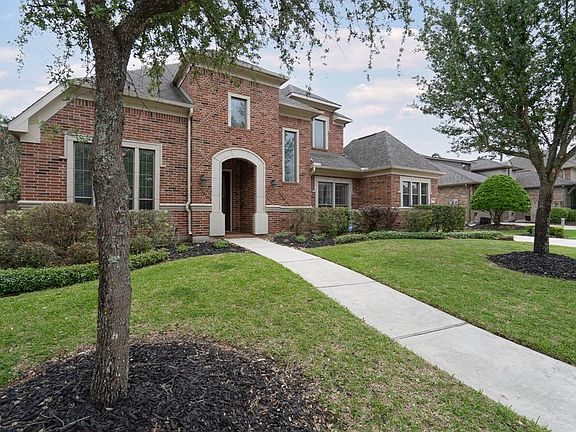 An arched walkway leads to the covered front porch and welcoming front door!