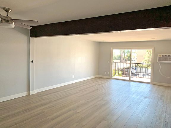 Dining area and living room with accent wood beam