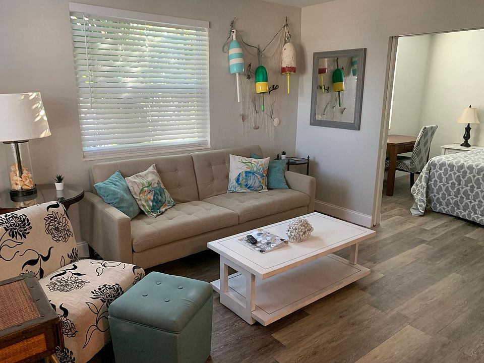 Unit 1A- Living Room decorated with a laid back, beachy vibe. Pocket doors offers open living between living space and bedroom.