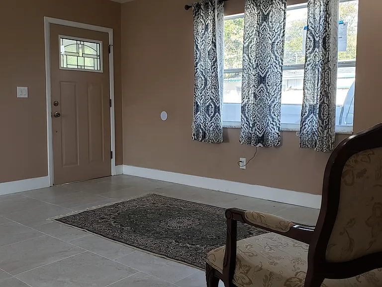 View of Living Area and Front Entry Door from Hallway.