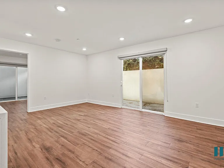 Spacious Living Room with Recessed Lighting , Vinyl Flooring, and Patio