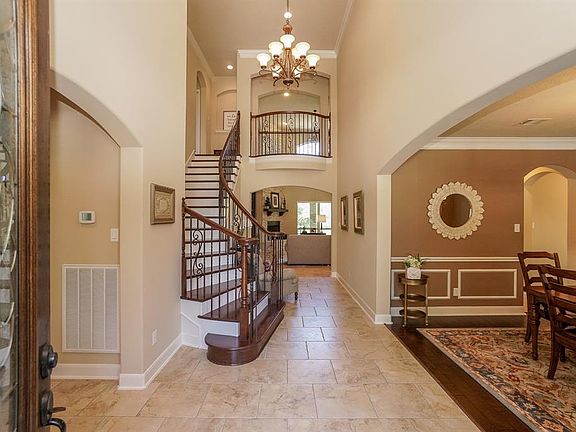 Dramatic foyer with rod-iron and wood wrap staircase!
