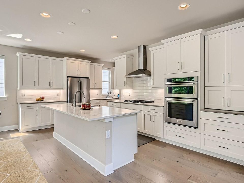 Quartz counters, tons of cabinets with pull outs and soft close feature, stainless steel KitchenAid appliances, gas stove, farmhouse sink, built-in trash and recycle.