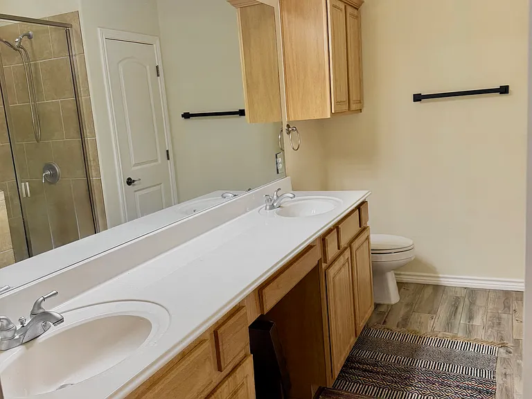Dual-sink vanity with full-length mirror and abundant counter space in the primary bathroom
