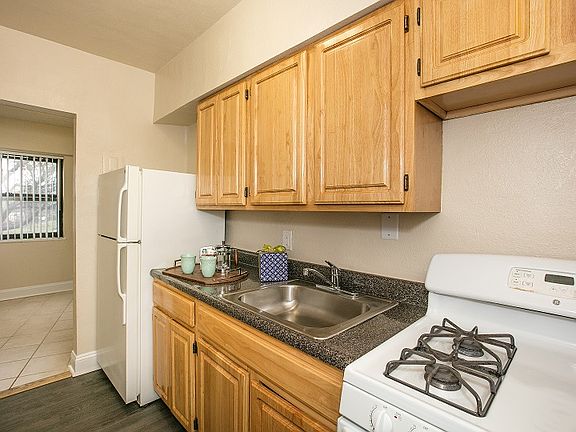 Kitchen with oak cabinets, white appliances and wood flooring