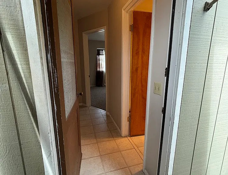 Back entrance. Bathroom to the right, bedroom straight ahead. Living/kitchen to the left.