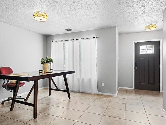 Entryway with a textured ceiling and light tile patterned floors