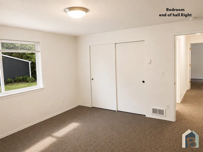 2nd floor large bedroom with view of lawn and mature evergreen trees and double closet