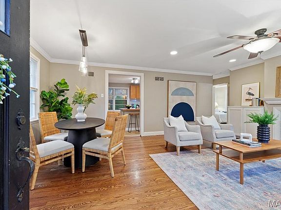 Spacious living/ dining room with refinished hardwood flooring and crown molding.