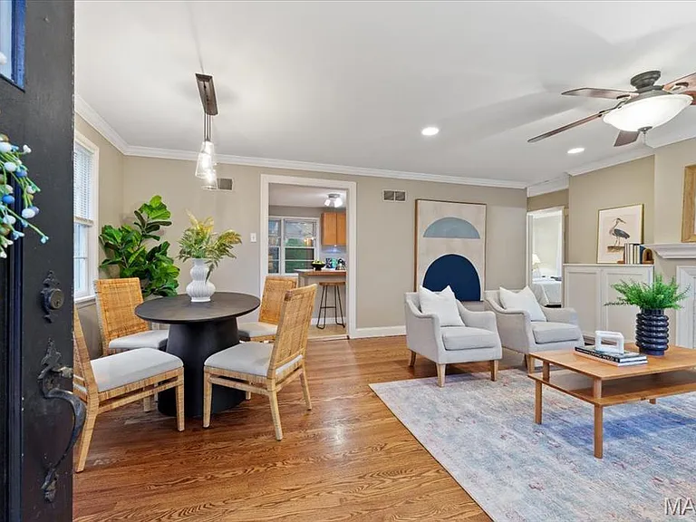 Spacious living/ dining room with refinished hardwood flooring and crown molding.